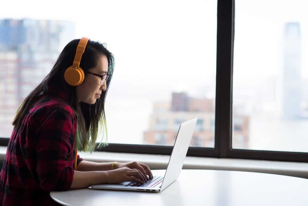 A person sitting and using a laptop, possibly using Windows 11